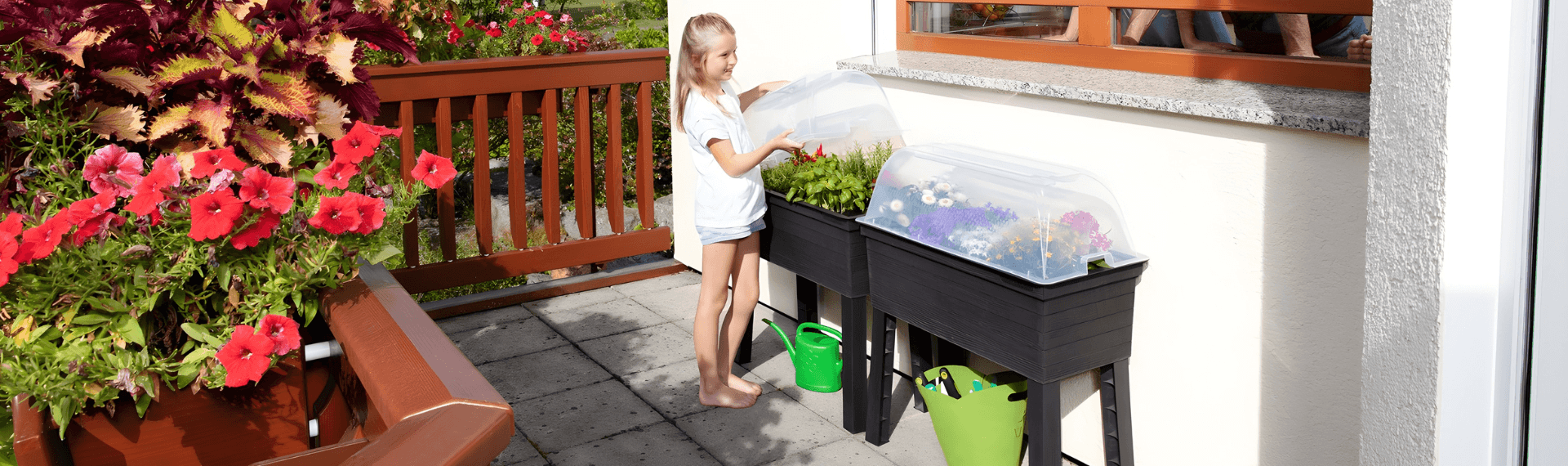 Kind auf Balkon am Hochbeet