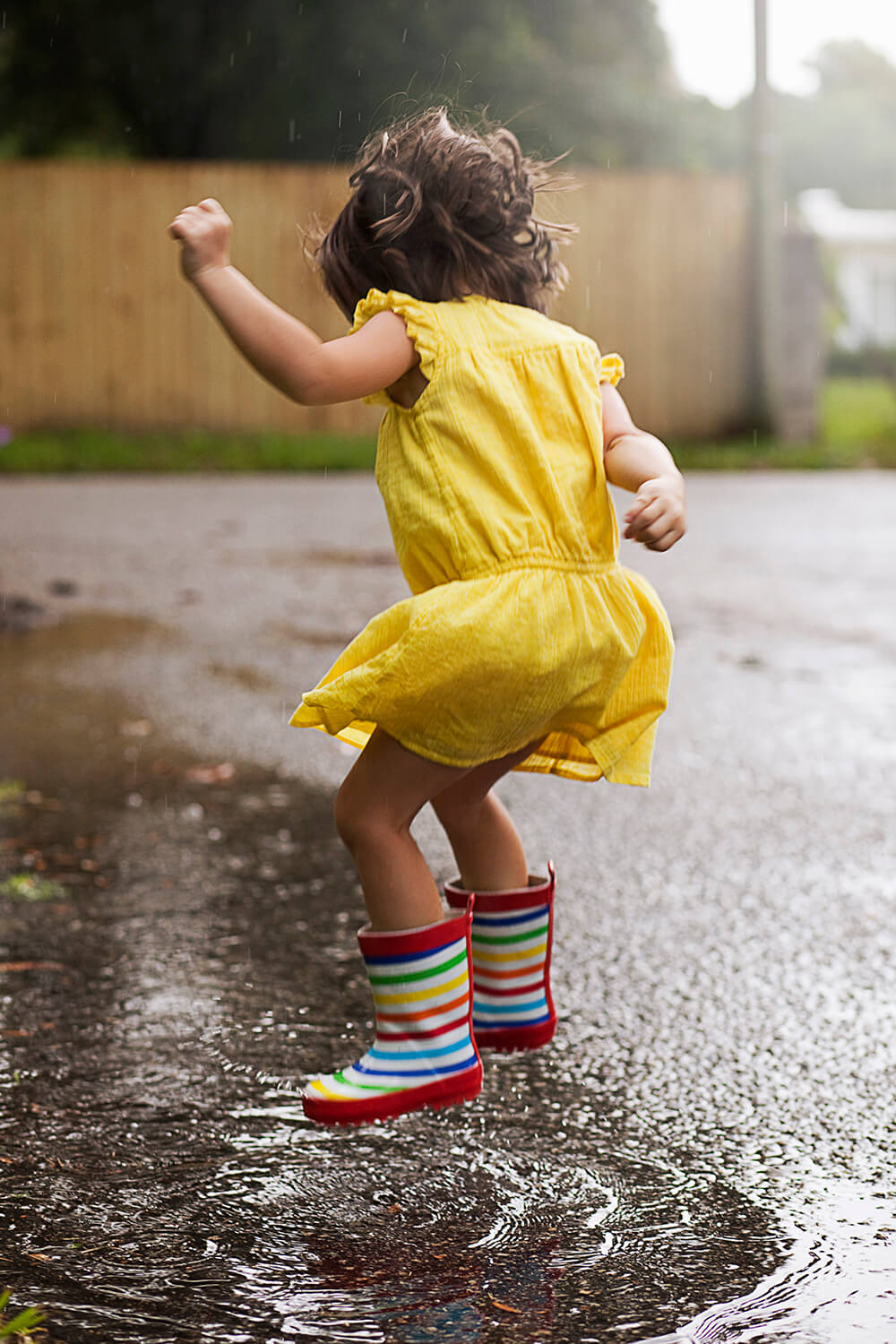 Image of a girl jumping in a rain puddle