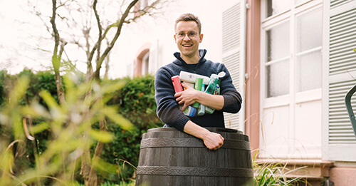 Hombre con botes de champú en los brazos